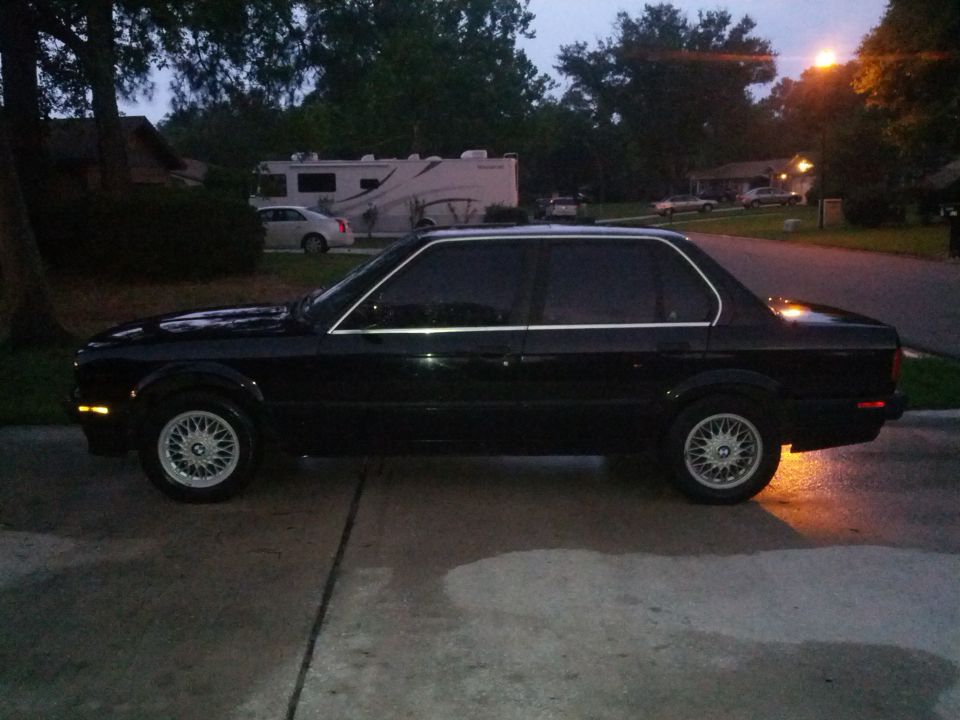 Black sedan with chrome trim and BBS-style wheels parked on a driveway