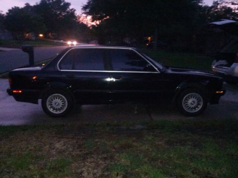 1991 BMW 3 Series - A black 1991 BMW 3 Series sedan is parked on a residential street at dusk.
