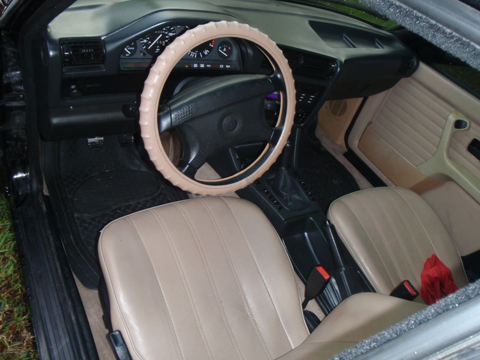 1991 BMW 3 Series interior with tan seats, beige steering wheel cover, and dashboard gauges