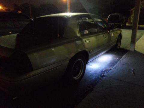 2000 Mercury Grand Marquis - A silver sedan is parked at night, illuminated by underglow lights.