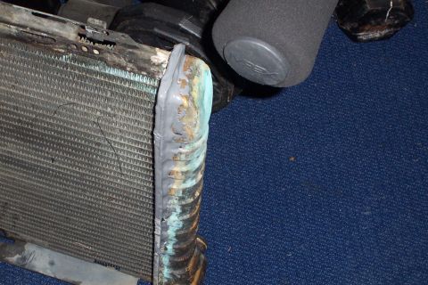 1980 Ford Bronco - Radiator repair using JB weld on the side tank, with visible corrosion.