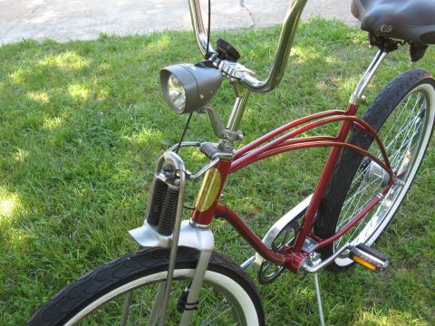 1994 Ford Bronco - A red cruiser bicycle is parked on a grassy lawn, showing its front wheel and handlebars.