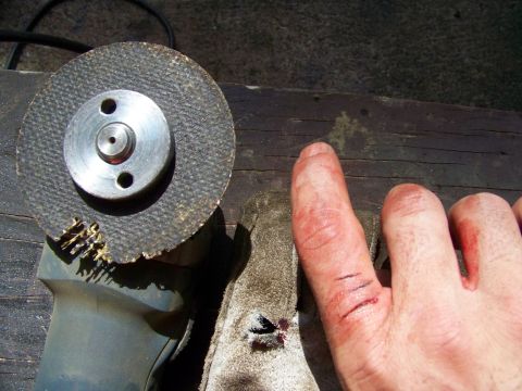 1985 Ford Bronco - An angle grinder disc sits next to an injured hand with cuts on the finger.