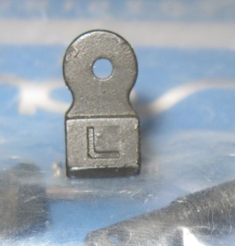 2000 Ford Crown Victoria - A close-up view of a metal bracket, possibly a vehicle part, with an 'L' marking.