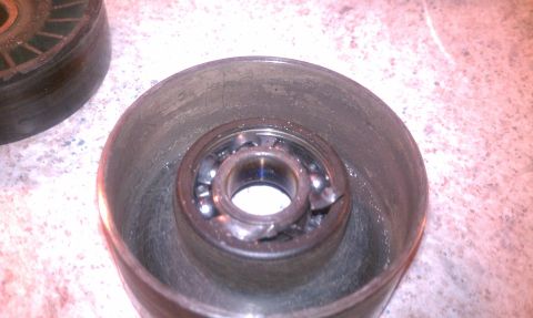 1995 Ford Bronco - A close-up view of a damaged pulley bearing, showing the compromised ball bearings and surrounding metal.