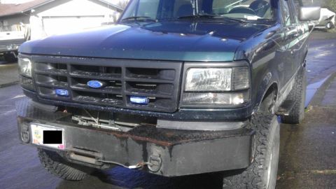 1995 Ford Bronco - This 1995 Ford Bronco features a dark green exterior, a black grille, and a heavy-duty aftermarket bumper.
