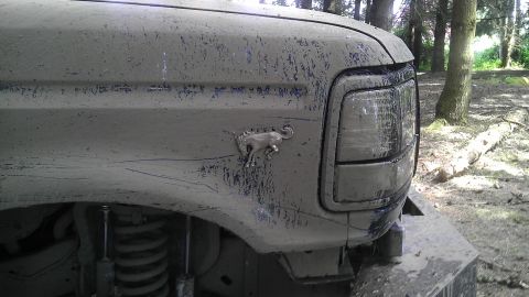 1995 Ford Bronco - Muddy 1995 Ford Bronco fender shows the running horse emblem and part of the headlight.