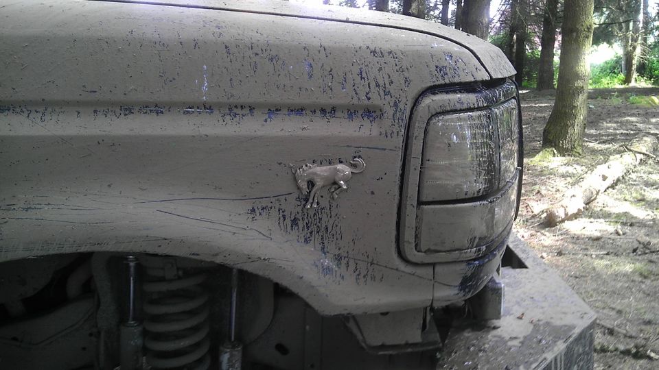 Mud-covered 1995 Ford Bronco fender with running horse emblem visible