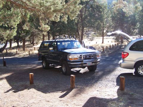1995 Ford Bronco - 1995 Ford Bronco parked in a campsite with a minivan in the background.