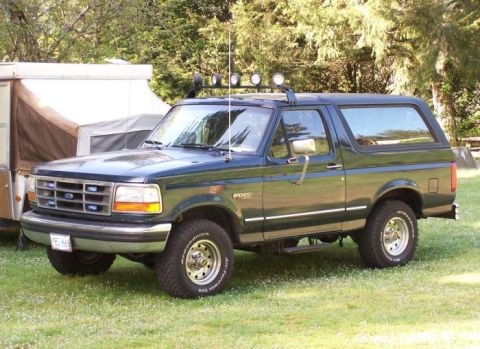 1995 Ford Bronco - This 1995 Ford Bronco is parked on a grassy area next to a pop-up camper.