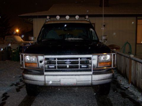 1995 Ford Bronco - Frontal view of a 1995 Ford Bronco covered in snow during a winter night.
