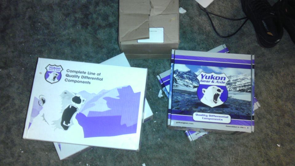 Two Yukon Gear & Axle boxes with polar bear logos and mountain graphics sit on a carpeted floor
