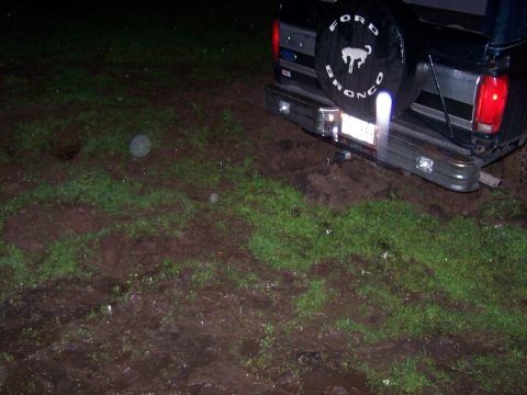 1995 Ford Bronco - Ford Bronco rear view stuck in muddy terrain at night.