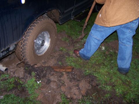 1995 Ford Bronco - A person is trying to free a vehicle that is stuck in the mud.