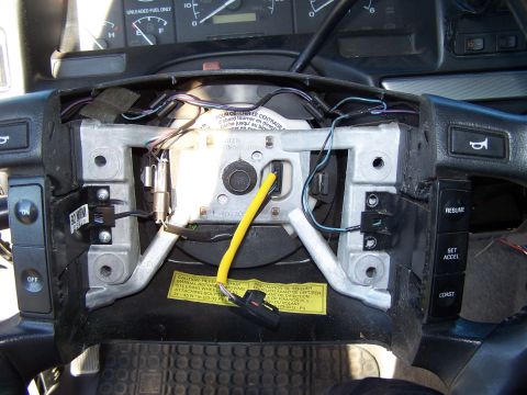 1995 Ford Bronco - Interior view of a 1995 Ford Bronco steering column, showing exposed wiring and dashboard components.