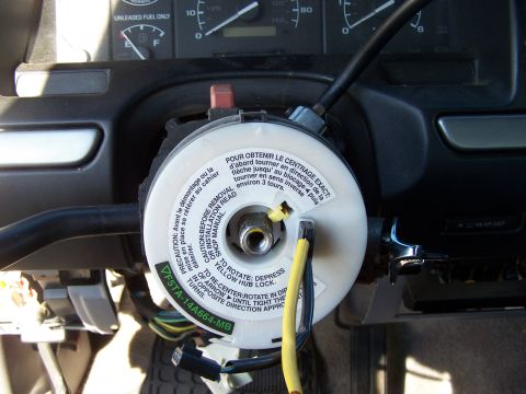 1995 Ford Bronco - Close-up of a vehicle's steering wheel clock spring assembly, showing wiring and operational instructions.