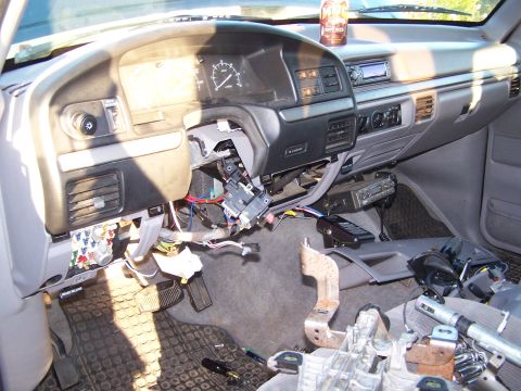 1995 Ford Bronco - The interior of a vehicle shows a dashboard that has been partially disassembled, revealing wiring and various components.