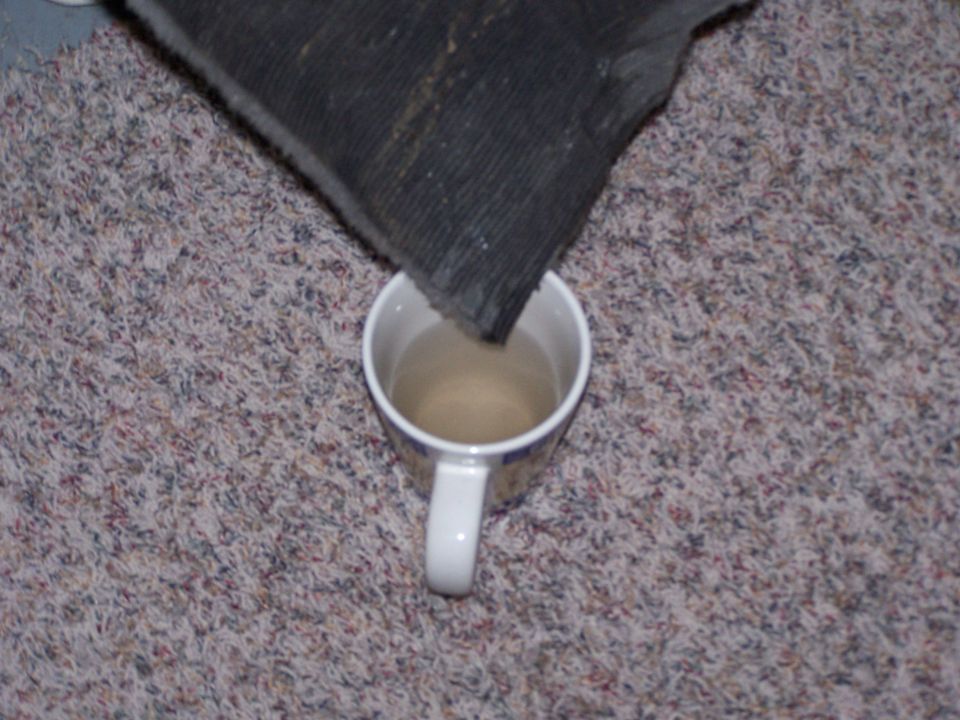 Carpet sample being dipped into a mug of liquid