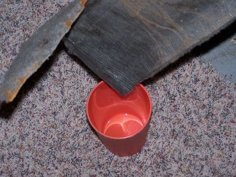 1995 Ford Bronco - A piece of carpet is placed over an orange plastic cup on a carpeted surface.