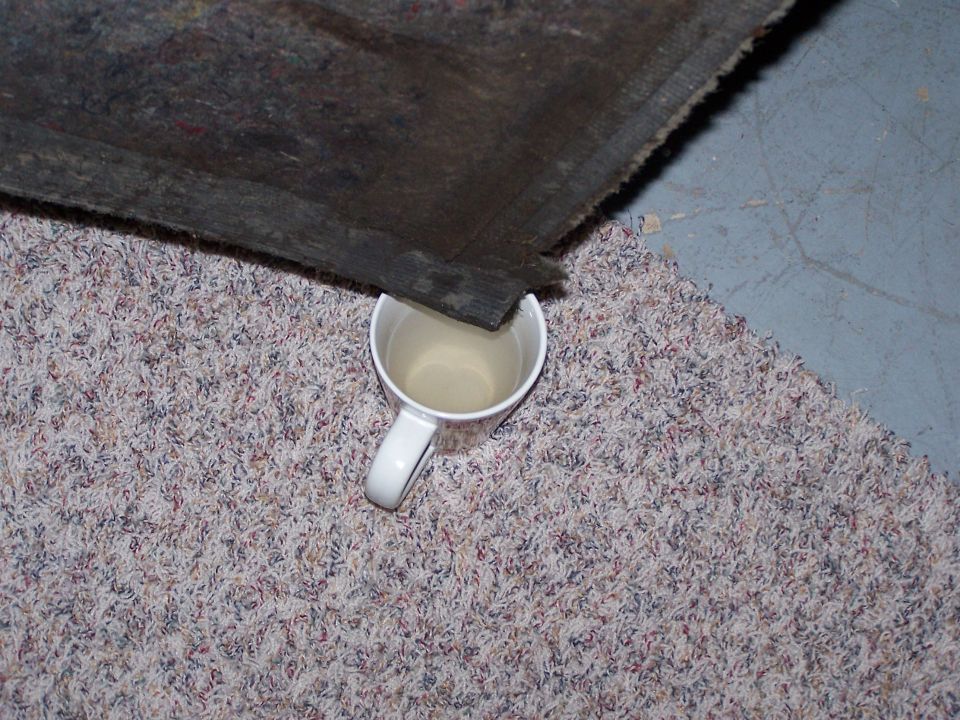 Bed liner edge over a mug of liquid on carpet