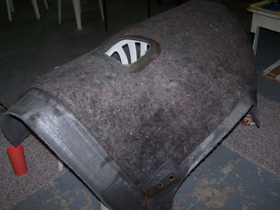 Interior trim panel with a white plastic vent, covered in grey carpet material