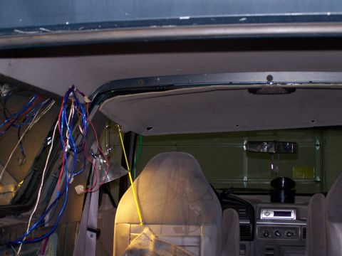 1995 Ford Bronco - The interior of a vehicle shows exposed wiring and the headliner, with a garage door visible in the background.
