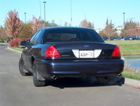 2001 Ford Crown Victoria - Rear view of a dark colored 2001 Ford Crown Victoria with exhaust smoke.
