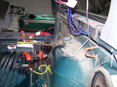 1995 Ford Bronco - Tools are laid out in the bed of a vehicle, with a boat visible behind it.