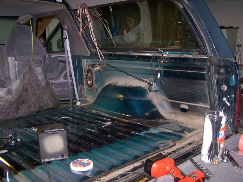 1995 Ford Bronco - The interior of a 1995 Ford Bronco shows exposed wiring and speakers in the cargo area.