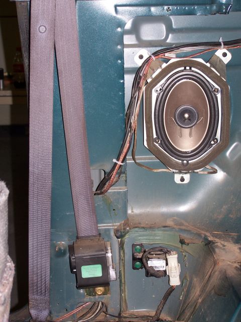 1995 Ford Bronco - Interior view showing a speaker and seatbelt mechanism, with visible wiring and mounting hardware.