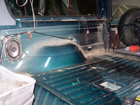1995 Ford Bronco - The rear interior of a vehicle shows the cargo floor and a speaker mounted on the side panel.