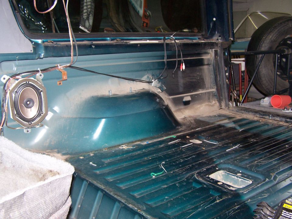 Interior of a vehicle's cargo area, showing a speaker mounted on the side panel and the ribbed floor