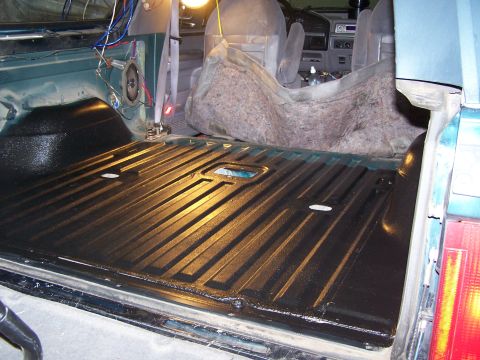 1995 Ford Bronco - The ribbed bed liner of a vehicle has been coated with a protective black material.