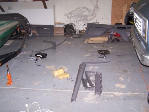 1995 Ford Bronco - Various car interior components are laid out on the floor of a garage, with a boat and truck visible.