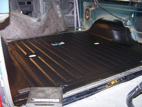 1995 Ford Bronco - The bed liner of a vehicle's interior cargo area is shown after some insulation has been removed.