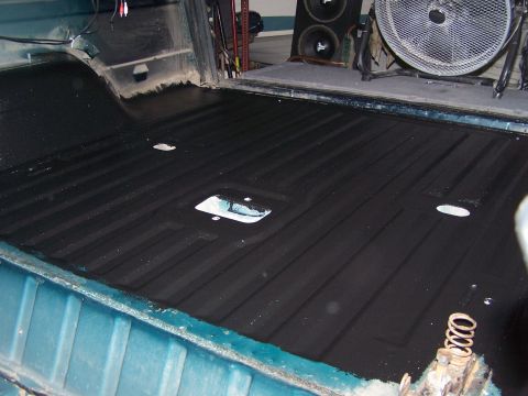 1995 Ford Bronco - The interior bed liner of a vehicle is shown, with a fan and speakers visible in the background.
