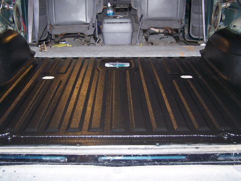 1995 Ford Bronco - The interior of a 1995 Ford Bronco shows a freshly coated bed liner and gray seats.