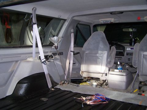 1995 Ford Bronco - The interior of a truck shows disassembled seats and exposed wiring, suggesting ongoing work or modifications.