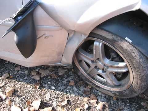 2001 Ford Taurus - This 2001 Ford Taurus shows significant damage to the front fender and a flat tire.