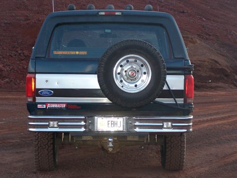 1995 Ford Bronco - Rear view of a dark blue Ford Bronco with a spare tire and "EB HJ" license plate.