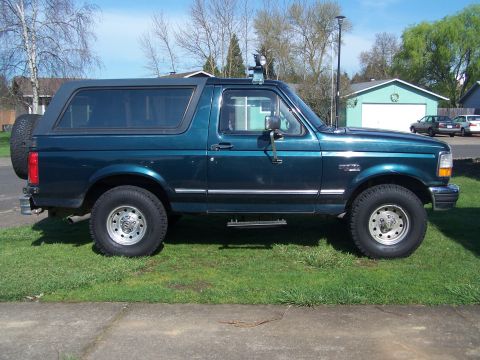 1995 Ford Bronco - This 1995 Ford Bronco is shown in a side profile, its dark teal paint and a spare tire mounted on the rear.
