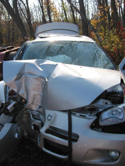 2001 Ford Taurus - This silver sedan has a severely damaged front end and deployed airbags, indicating a significant collision.