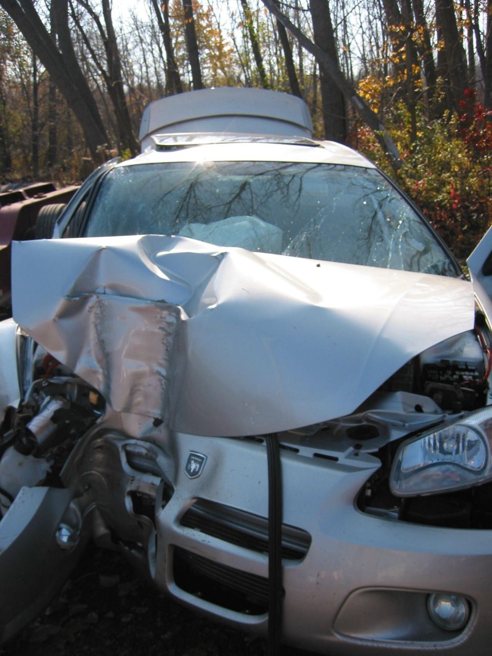 Silver sedan with deployed airbags and heavily damaged front end