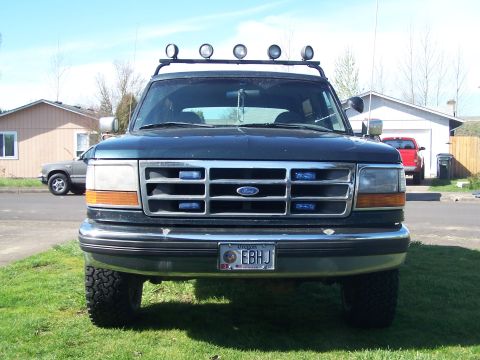 1995 Ford Bronco - This 1995 Ford Bronco is parked in a residential driveway with a second vehicle visible in the background.