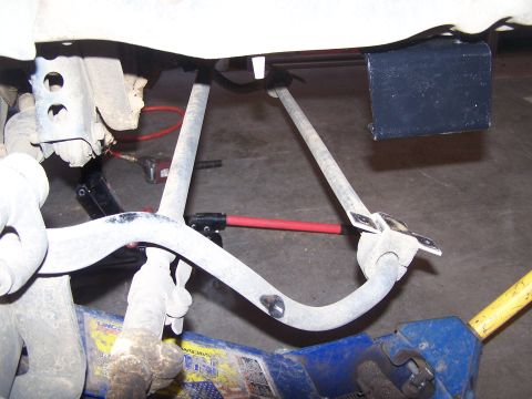 1995 Ford Bronco - Close-up view of vehicle suspension components and a hydraulic jack.