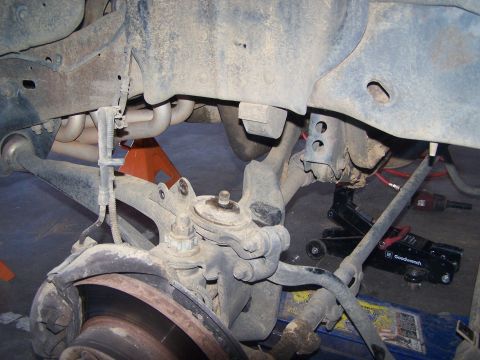 1995 Ford Bronco - Close-up view of a vehicle's suspension system, including suspension components and exhaust headers.