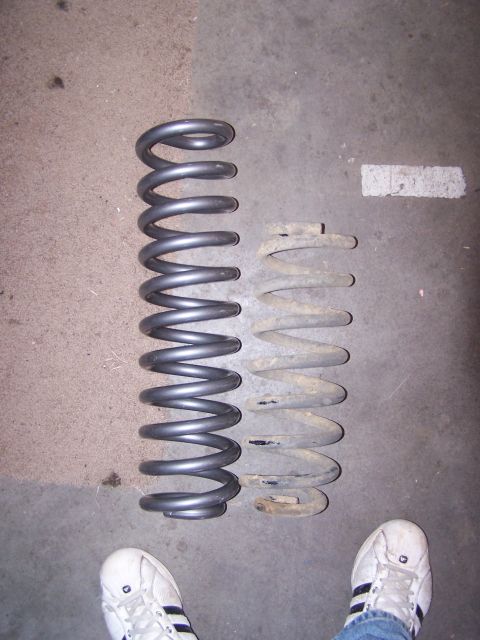 1995 Ford Bronco - Comparison of a new coil spring with an older, rusted one, likely for a vehicle suspension upgrade.