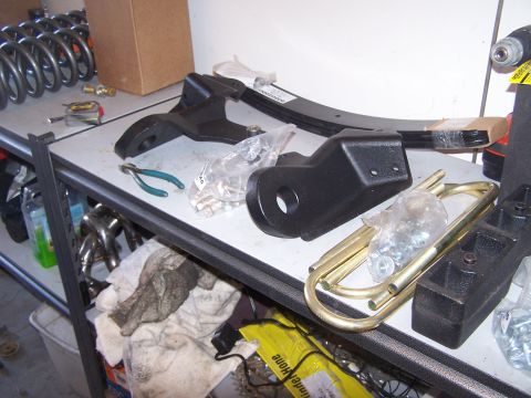 1995 Ford Bronco - Various automotive suspension components are laid out on a shelf, ready for installation.