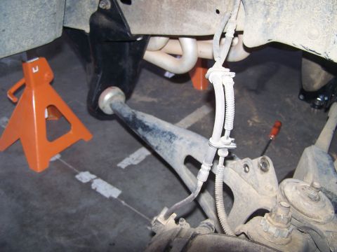 1995 Ford Bronco - Close-up view of vehicle suspension components, indicating a lift kit installation with jack stands supporting the frame.