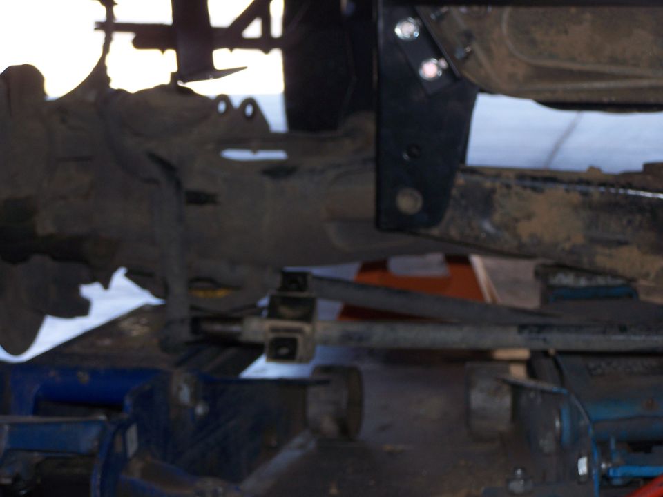Close-up of a vehicle's lifted suspension with a black bracket and metal components